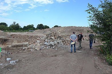 Die Reste der Fundamente, die dabei noch auftauchen, werden gesammelt, um im Brecher   zerkleinert zu werden.